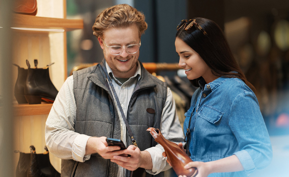 Un addetto alle vendite usa l’iPhone per aiutare una cliente in negozio.
